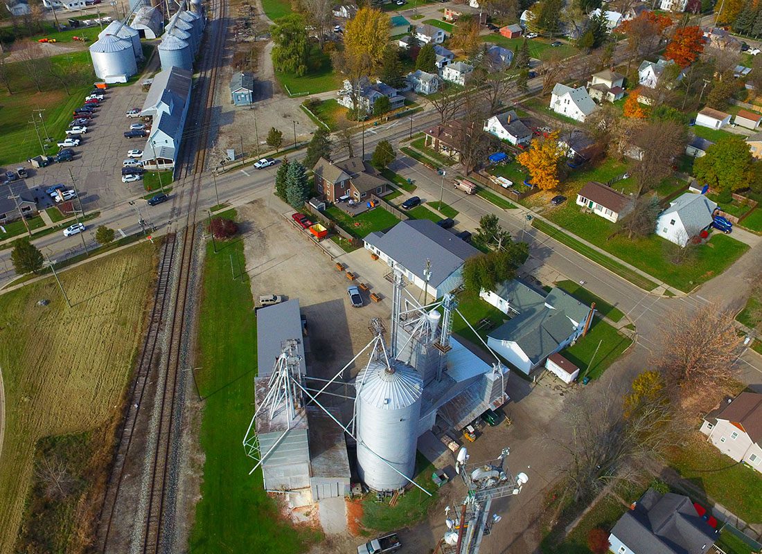 Rockford, MI - Aerial View of a Town With Homes and Silos With Train Tracks